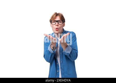 Jeune homme joyeux aux cheveux rouges vêtu d'une chemise bleue au-dessus d'un t-shirt Banque D'Images