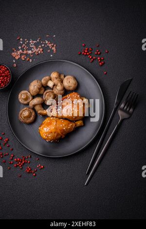 Délicieux plat asiatique avec cuisses de poulet en sauce teriyaki avec sel et épices sur fond de béton foncé Banque D'Images