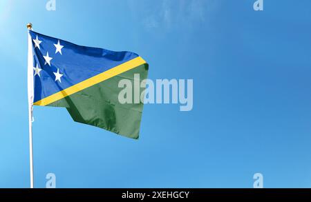 Drapeau des Îles Salomon sur ciel nuageux. ondulant dans le ciel Banque D'Images