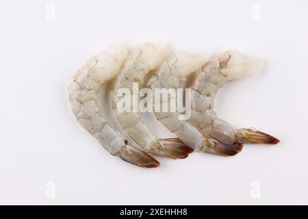 Fruits de mer. Crevettes royales vertes crues dans une assiette blanche avec romarin, citron, ail et sel sur fond gris clair. Backgr Banque D'Images