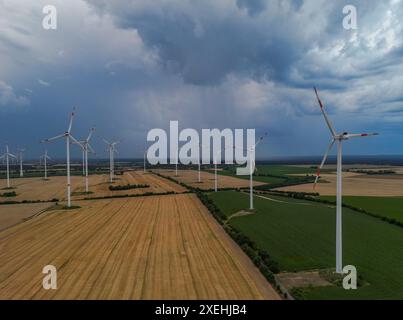 Sieversdorf, Allemagne. 27 juin 2024. Les nuages sombres d'un orage approchant passent au-dessus du parc éolien 'Odervorland' dans le district d'Oder-Spree dans l'est du Brandebourg (vue aérienne avec un drone). Crédit : Patrick Pleul/dpa/Alamy Live News Banque D'Images