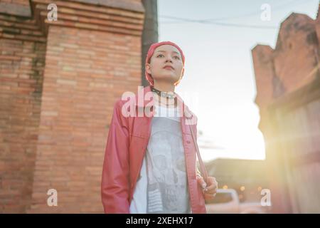 Gen z fille mode en cuir avec punk asiatique femme touriste de la ville locale Asie du Sud-est voyage tendance coiffure rose jeune femme Banque D'Images