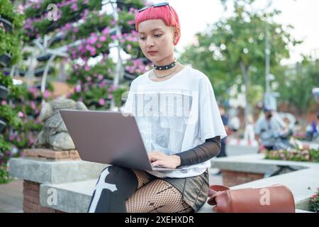 Gen z fille mode en cuir avec femme asiatique punk travaillant à distance sur ordinateur portable nomade numérique en Thaïlande Banque D'Images
