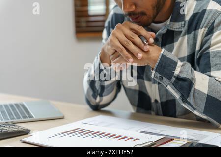 Homme d'affaires réfléchi pense au projet en ligne sérieux homme d'affaires millénaire utilisant un ordinateur portable et professionnel travaillant dedans Banque D'Images