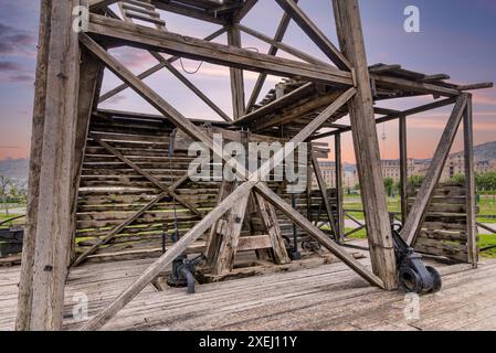 Vue rapprochée du premier puits de pétrole foré industriellement à Bakou, Azerbaïdjan. La structure en bois du puits est visible, ainsi qu'un aperçu de l'horizon de la ville en arrière-plan Banque D'Images