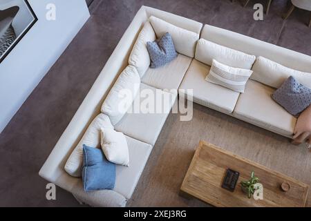 Vue de dessus du salon moderne avec canapé sectionnel confortable et table basse en bois, espace photocopie Banque D'Images