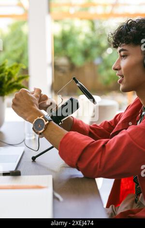 À l'aide d'un microphone et d'un casque, jeune homme enregistrant un podcast à la maison Banque D'Images