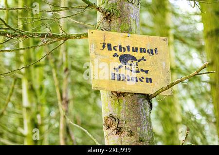 Signe d'avertissement allemand de la seconde Guerre mondiale cloué à un arbre dans un bois. Le signe a un crâne et des os croisés et dit attention Mines en allemand Achtung! Minen Banque D'Images