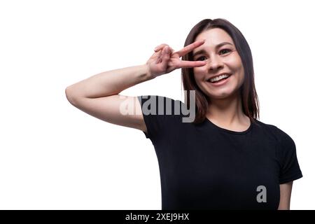 Jeune femme brune élancée aux cheveux courts et droits portant un T-shirt noir Banque D'Images