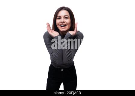 Femme de 25 ans bien soignée vêtue d'un T-shirt de base noir sourit joyeusement Banque D'Images
