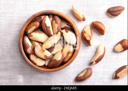 Noix du Brésil dans un bol en bois sur tissu de lin. Graines séchées de Bertholletia excelsa sans coquille. Banque D'Images