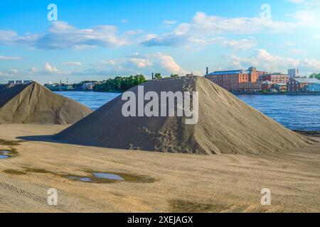 Des tas de gravier, des pierres concassées, des cailloux dans le port, un grand stockage de minéraux en vrac et de pierres sur le rivage du port dans la ville. Banque D'Images