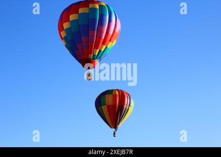 Ascension à l'aube de ballons vibrants au-dessus de l'eau Banque D'Images