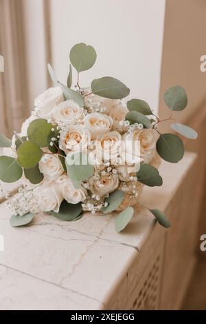 Bouquet de mariée avec roses blanches et eucalyptus sur surface de marbre Banque D'Images