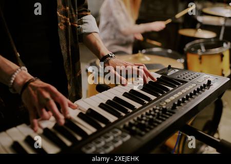 Gros plan des mains d'un musicien masculin méconnaissable jouant synthétiseur dans un groupe de rock Banque D'Images