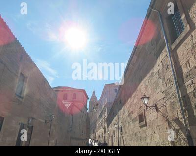 rue avec le soleil brille au-dessus, flanquée de vieux bâtiments en pierre Banque D'Images