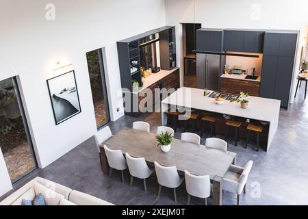 Cuisine moderne et salle à manger avec grande table, chaises et comptoir îlot, espace photocopie Banque D'Images