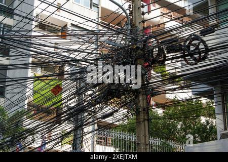 Chaos des câbles et des fils à Bangkok, en Thaïlande, les fils électriques et téléphoniques se sont enroulés sur un lampadaire Banque D'Images