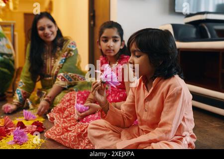 Les enfants font des Rangoli avec maman Banque D'Images