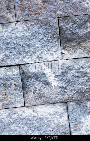 Une perspective rapprochée d'un mur de briques avec diverses taches couvrant sa surface, mettant en valeur un mélange de matériaux composites et de motifs comme des rectangles Banque D'Images