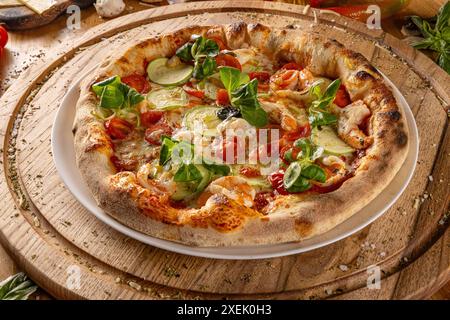 Délicieuse pizza italienne avec crevettes et courgettes sur planche à découper en bois Banque D'Images