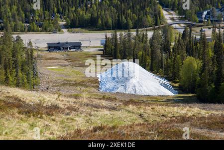 Dépôt de neige (enneigement) dans un domaine skiable finlandais pour le stockage en raison du réchauffement climatique dû au changement climatique Banque D'Images