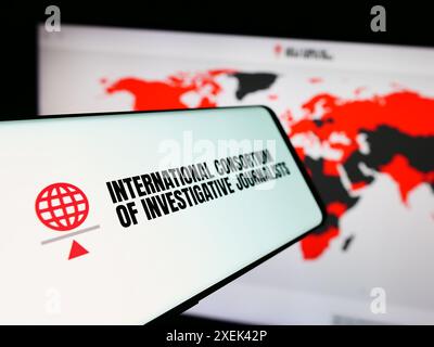 Smartphone avec logo du Consortium international des journalistes d'investigation (ICIJ) devant le site Web. Focus à gauche de l'écran du téléphone. Banque D'Images