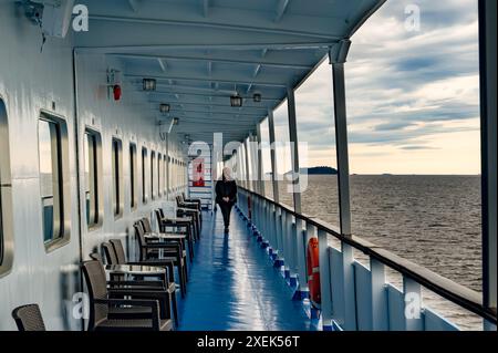 Pont d'un navire, vue sur le lac, mer du nord à bord d'un navire de croisière. Silhouette méconnaissable d'une femme qui marche et se repose. Le thème du voyage en no Banque D'Images