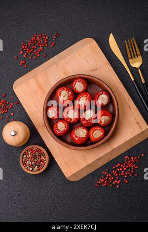 Poivrons rouges farcis au fromage ou à la viande avec du sel, des épices et des herbes Banque D'Images