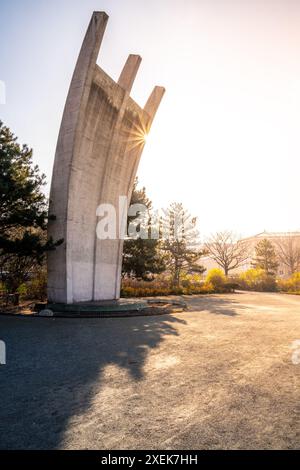 Le Berlin Airlift Memorial baignait dans la lueur chaude d'un lever de soleil, avec le terminal de l'aéroport Tempelhof en arrière-plan. Banque D'Images
