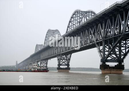 JIUJIANG, CHINE - 28 JUIN 2024 - les navires naviguent devant le pont du fleuve Jiujiang Yangtze avec des niveaux d'eau élevés, la plupart des quais submergés par l'eau de la rivière Banque D'Images