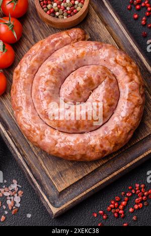 Délicieuse saucisse grillée en forme d'anneau avec du sel, des épices et des herbes Banque D'Images