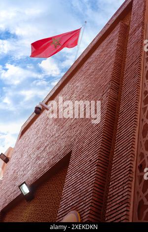 Drapeau national marocain rouge flattes tissu de soie contre le ciel, étoile à cinq branches, bâtiment du gouvernement, jour de l'indépendance, commerce mondial, affaires et cou Banque D'Images