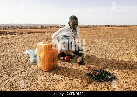 Mauritanie, environs de M'Hareth, homme préparant le thé au bord d'une piste Banque D'Images