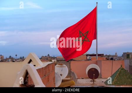 Drapeau national marocain rouge flattes tissu de soie contre le ciel, étoile à cinq branches, bâtiment du gouvernement, jour de l'indépendance, commerce mondial, affaires et cou Banque D'Images