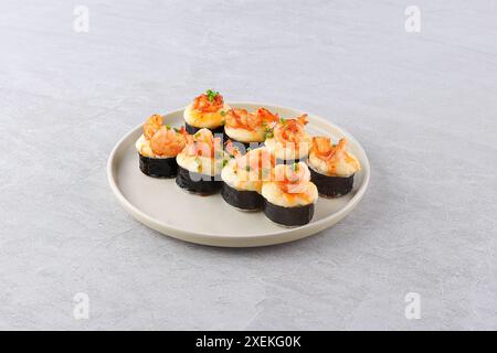 Ensemble de rouleau de sushi cuit au four avec des crevettes et du saumon sur un fond noir. Cuisine japonaise, photo pour le menu Banque D'Images