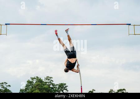 vue arrière de la voûte à perche d'un athlète masculin lors des matchs d'athlétisme d'été Banque D'Images