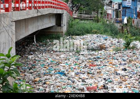 Dhaka, Bangladesh - 28 juin 2024 : gaspillage de matières plastiques et de produits chimiques toxiques provenant d'usines mourantes déversées dans un canal à Uttar Manda à Dhaka, Bangla Banque D'Images