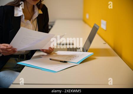 Femme caucasienne triant une pile de documents sur son bureau Banque D'Images