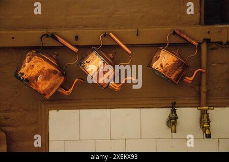 Casseroles et bouilloires en cuivre dans la cuisine du château de Belvoir, Leicestershire, Royaume-Uni. Banque D'Images