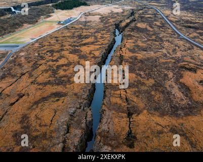 Vue aérienne d'une fissure profonde remplie d'eau dans le terrain rocheux d'Islande Banque D'Images