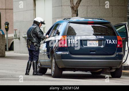 Un policier de la circulation parle à un chauffeur de taxi à San Francisco, Californie, États-Unis. après un accident de la route impliquant un piéton. Banque D'Images