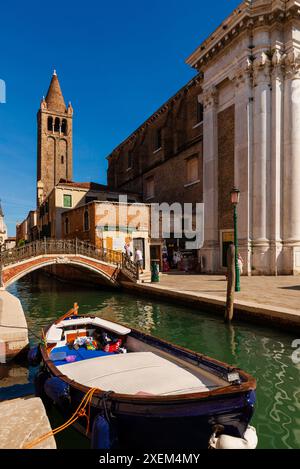 Bateau flottant dans un canal avec une passerelle et une tour le long de la voie navigable à Venise ; Venise, Vénétie, Italie Banque D'Images