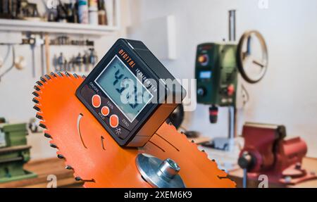 Inclinomètre électronique avec affichage numérique sur disque orange de scie à onglet motorisée. Gros plan de l'outil précis pour mesurer la pente angle.inside salle de travail. Banque D'Images