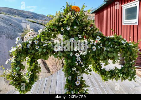 Midsommarstång, midsummar pole, maypole, décoré de verts et de fleurs. Archipel de Fjällbacka, ouest de la Suède. Juin 2024d Banque D'Images