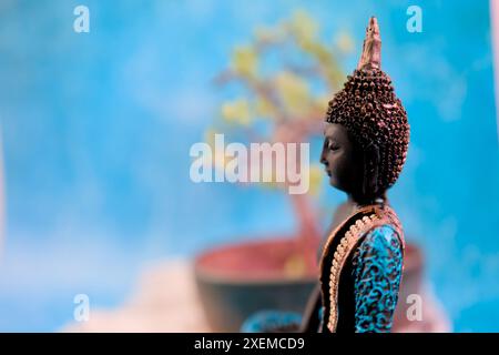 Une image paisible avec une statue de Bouddha baignée d'une douce lumière bleue. Parfait pour les milieux de méditation Banque D'Images