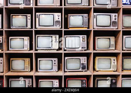 Pékin, Chine - 17 juin 2024 : mur de vieux téléviseurs à tube. Un fond d'étagères avec de petits téléviseurs. Photo de haute qualité Banque D'Images