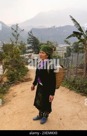 Femme portant un panier sur son dos sur un chemin de terre à son la, Vietnam ; Ngoc chien, Muong la District, son la, Vietnam Banque D'Images