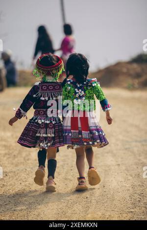 Deux jeunes filles marchent main dans la main sur une route de campagne au Vietnam ; Ban Nam Nghiep, Muong la, son la, Vietnam Banque D'Images