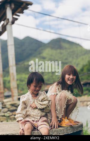 Deux jeunes filles passent du temps ensemble à l'extérieur ; Ngoc chien, Muong la District, son la, Vietnam Banque D'Images